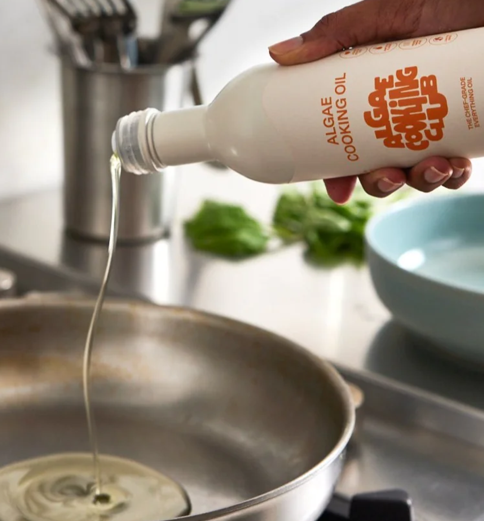 Algae Cooking Club algae cooking oil being poured into a stainless steel pan
